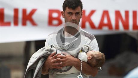 Un réfugié syrien, un bébé dans les bras, au camp de Yayladagi, en Turquie.